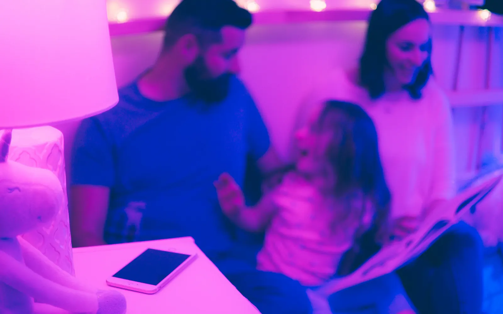 A lit bedroom, book open, child mid-laugh
